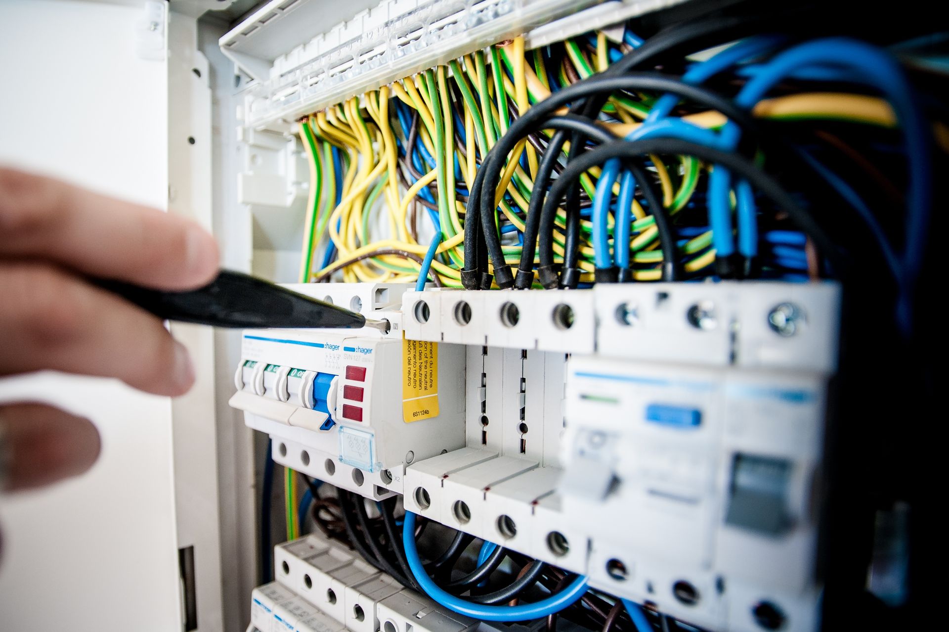 Close-up of an electrician working on a circuit breaker panel